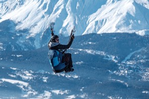 Пилот в подвеске Sky Paragliders Gii 5 в полёте над горами